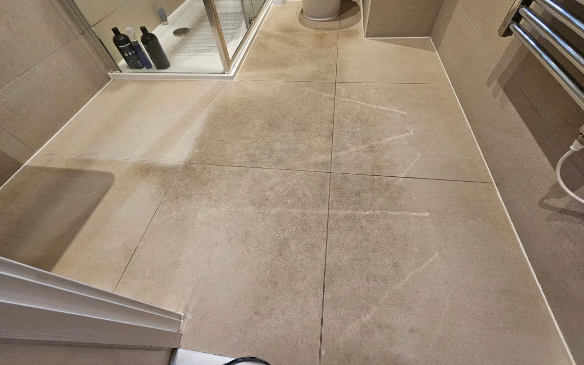 Bathroom matte tile floor with cloudy surface haze before professional restoration