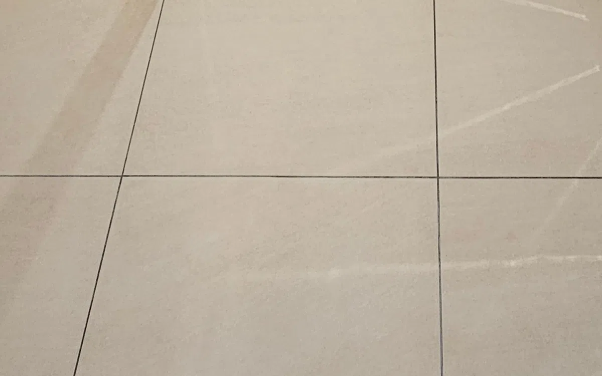Specialist restoring a worn matte tiled floor