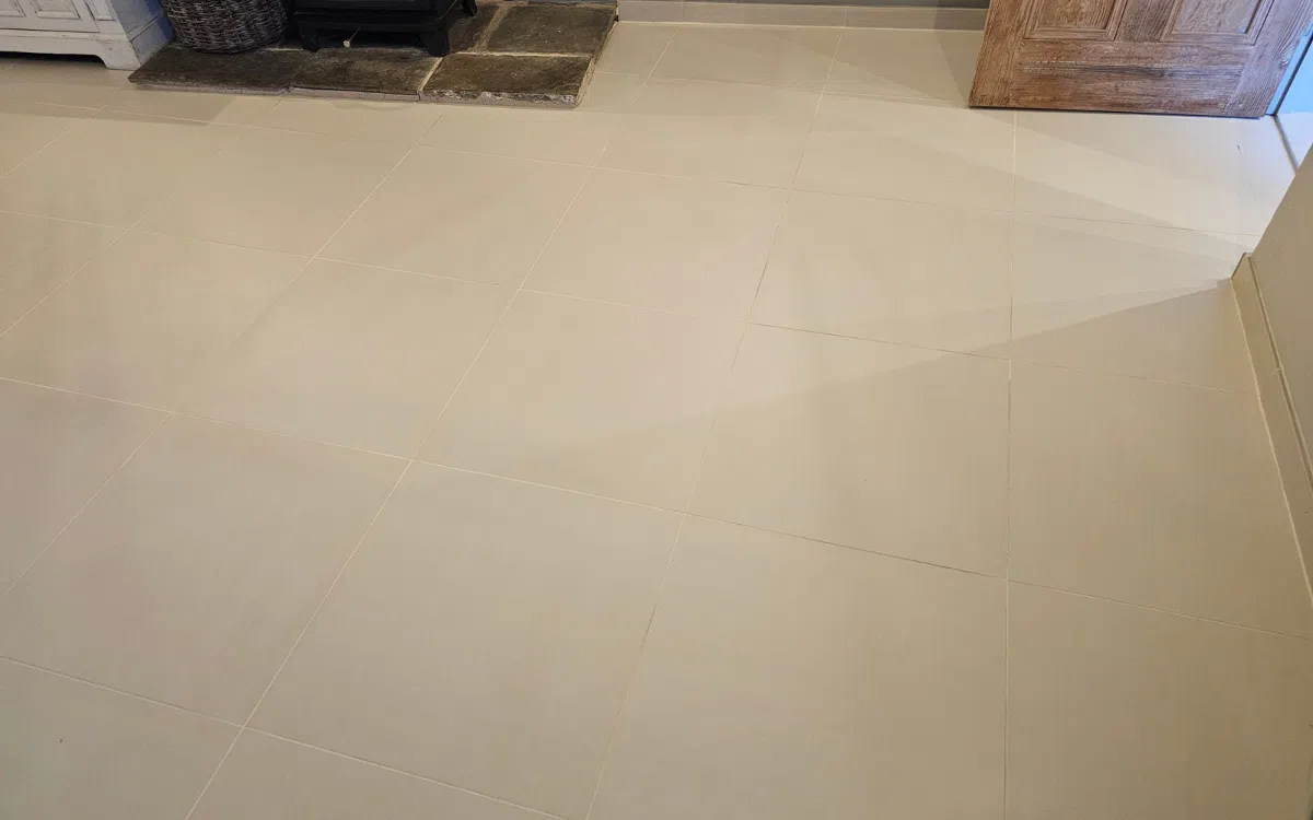 Tiled floor with uneven and less clearly defined grout lines before professional sealing