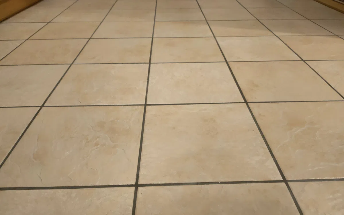 Indoor tiled floor with cleaner tiles and defined grout lines after professional cleaning