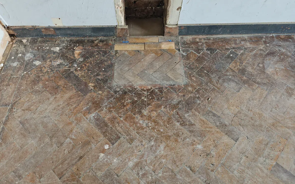 Worn school parquet floor before restoration